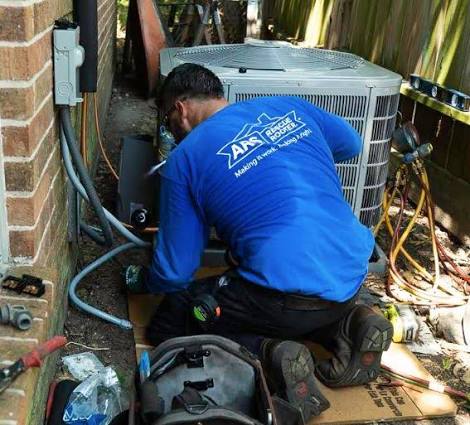 Technician repairing an outdoor air conditioning condenser