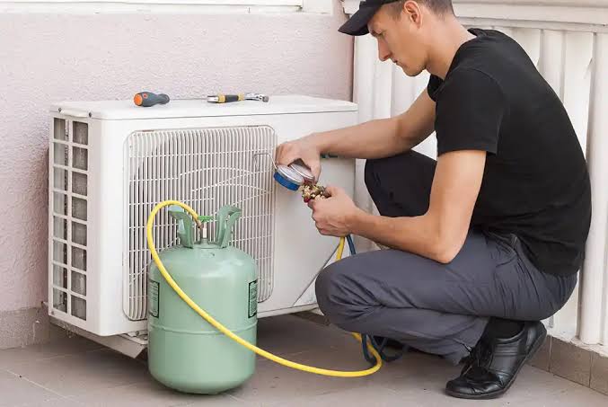 Technician checking pressure on an outdoor mini-split HVAC unit