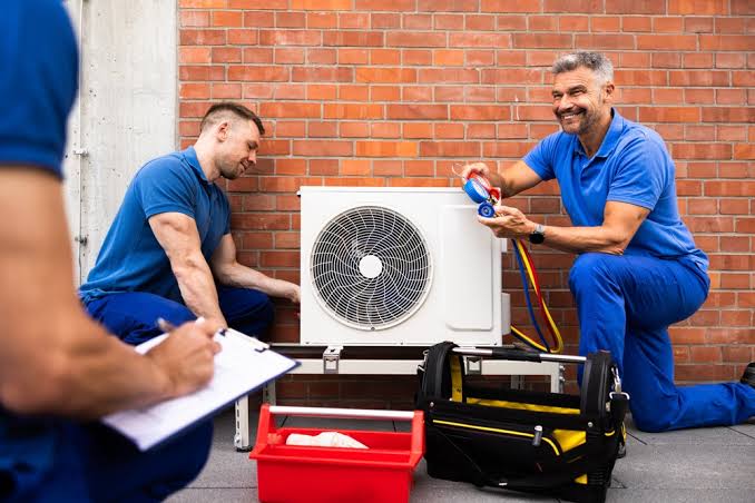 HVAC technicians servicing a residential air conditioning system
